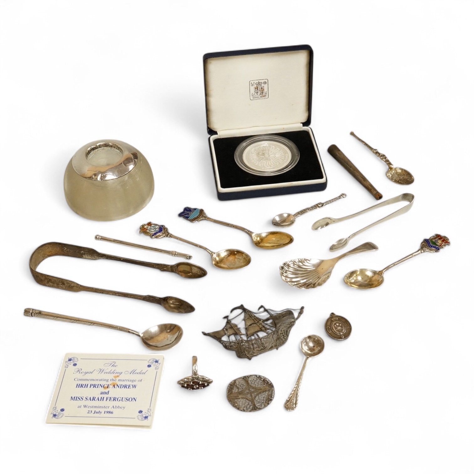 Assorted small silver including a mounted ribbed glass match strike, height 40mm, a small Scottish sterling spoon by Hamish Dawson Bowman, 76mm, a pair of George IV silver sugar tongs, commemorative spoons, an early 20th